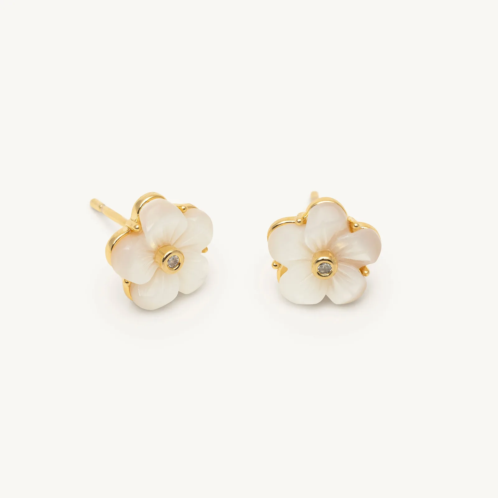 Carved dark shell flower stud earrings with a crystal centre in cream