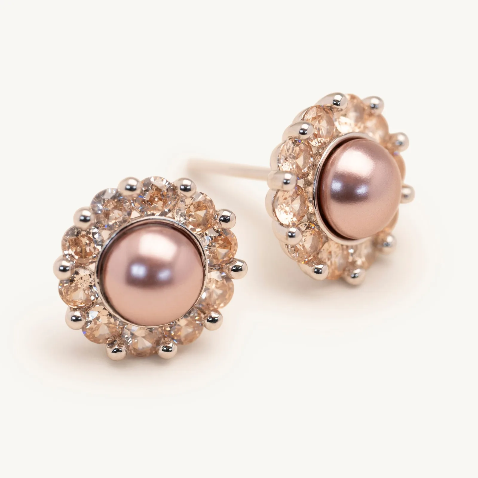 Pink pearl stud earrings framed by champagne crystals